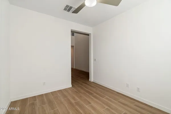 a view of an empty room with wooden floor