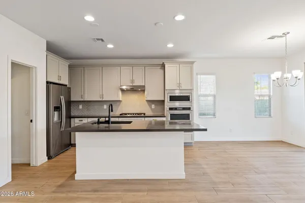 a kitchen with stainless steel appliances granite countertop a sink and a refrigerator