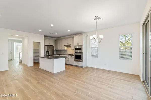 a large kitchen with granite countertop a large kitchen island a refrigerator and a sink