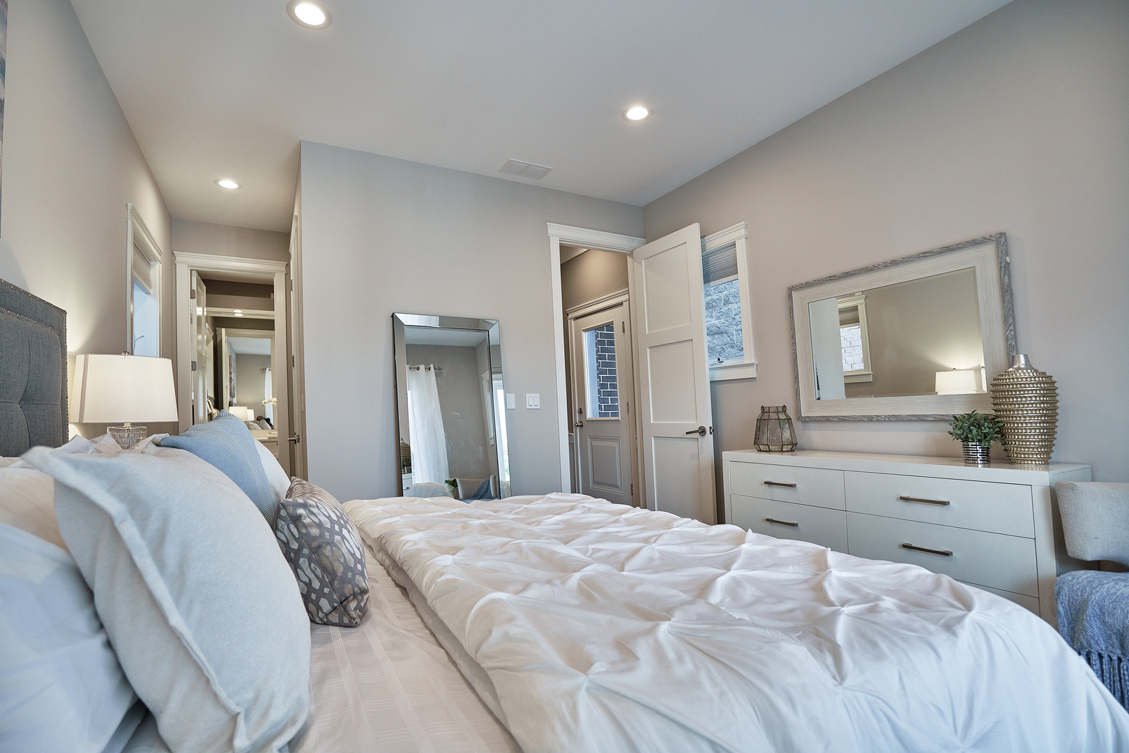 3044 North Racine Avenue, Unit 2 Chicago, IL 60657 - Photo 16 of 27 a spacious bedroom with a bed and a large mirror