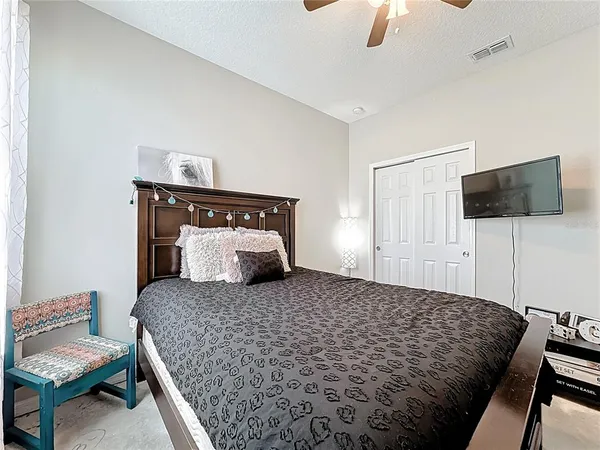 a bedroom with a large bed and a chandelier