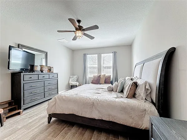 a bedroom with a bed and wooden floor