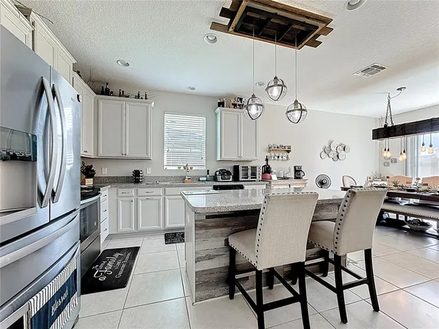 a kitchen with granite countertop white cabinets and stainless steel appliances