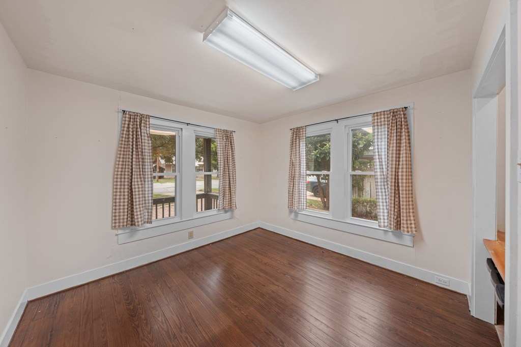 1209 Park Street Kerrville, TX 78028 - Photo 11 of 28 a view of an empty room with wooden floor and windows