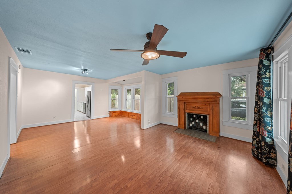 1209 Park Street Kerrville, TX 78028 - Photo 7 of 28 a view of empty room with wooden floor fireplace and a window