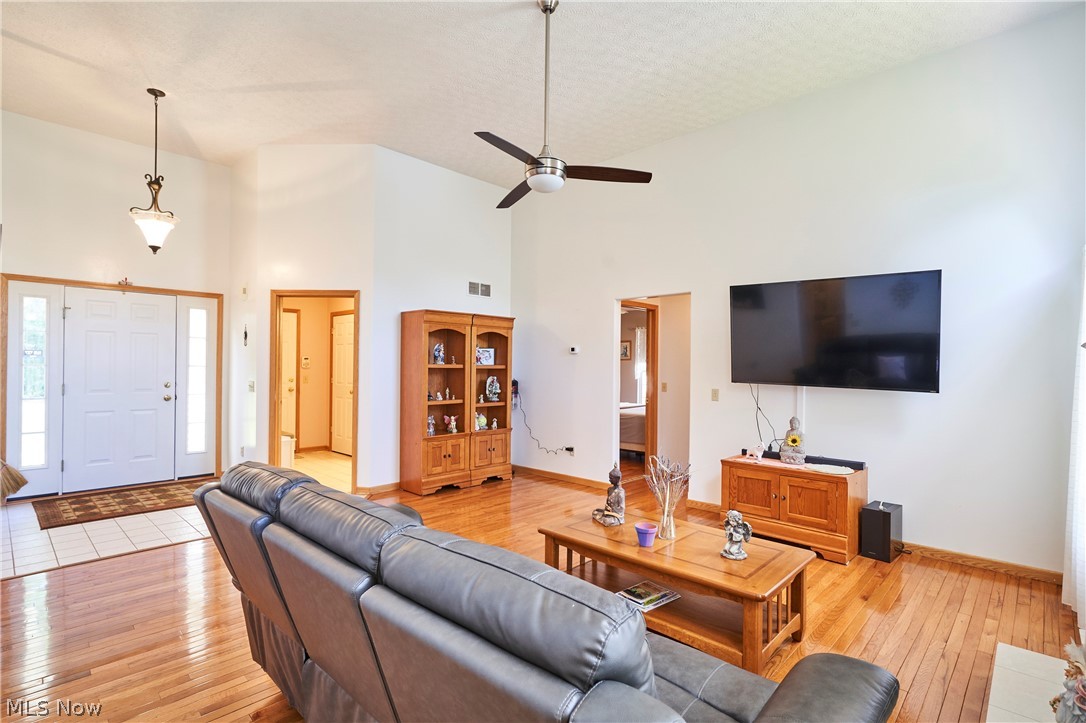1963 Haines Road Madison, OH 44057 - Photo 8 of 34 Open concept living area featuring vaulted ceilings, wood-finish flooring, and a ceiling fan