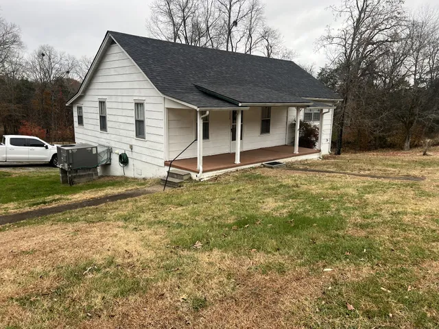 a view of a house with backyard and chairs