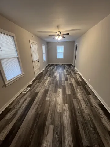 a view of empty room with wooden floor