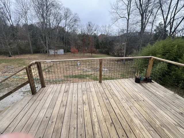 a view of balcony with wooden floor and fence