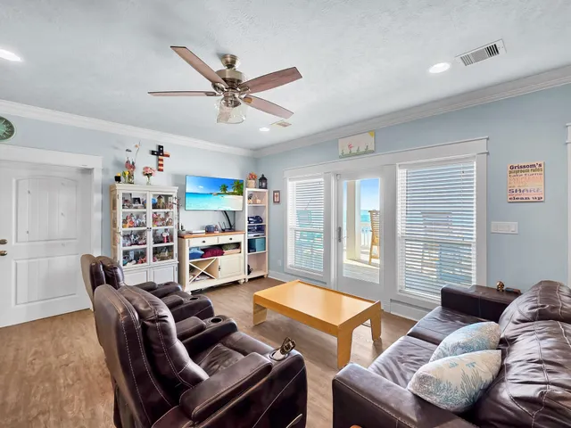 a living room with furniture a flat screen tv and a large window