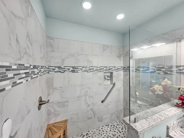 a kitchen with stainless steel appliances granite countertop a stove a refrigerator a kitchen island a sink white cabinets and chairs