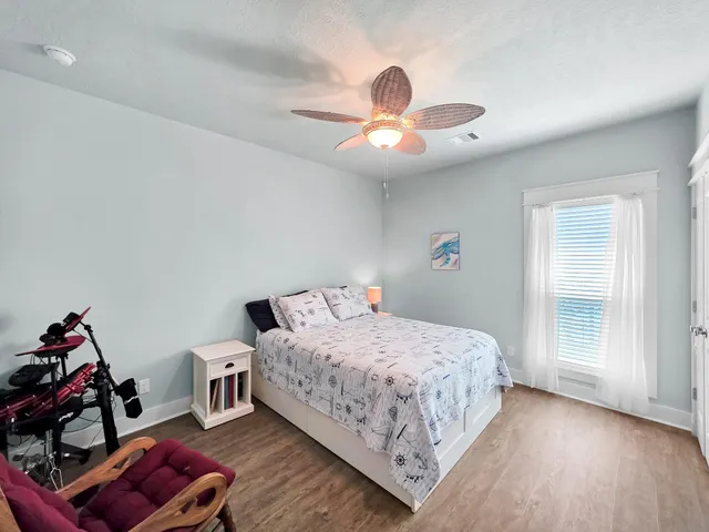 a view of a hallway with wooden floor and windows