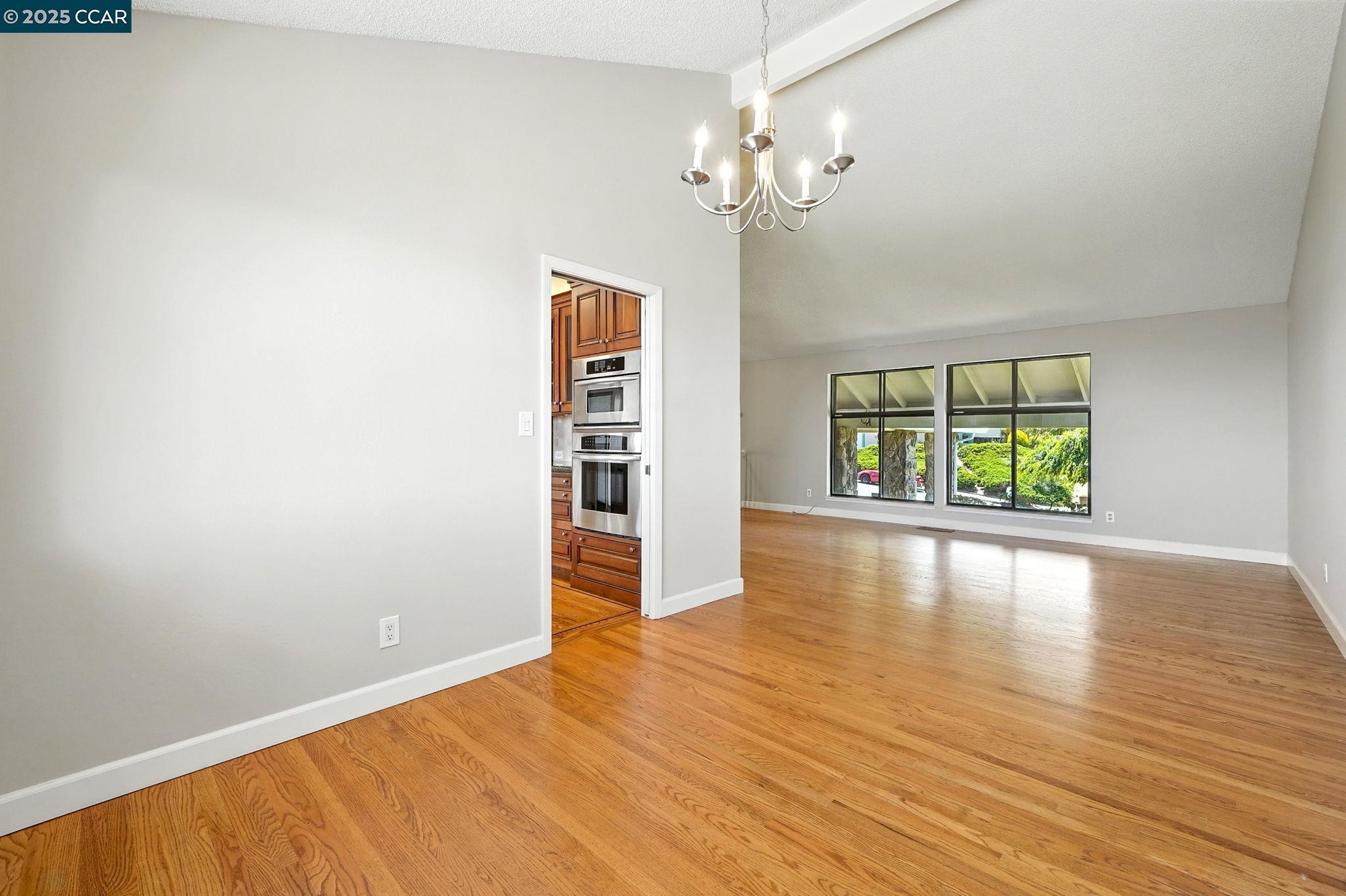 267 Duperu Drive Crockett, CA 94525 - Photo 9 of 50 an empty room with wooden floor chandelier and windows