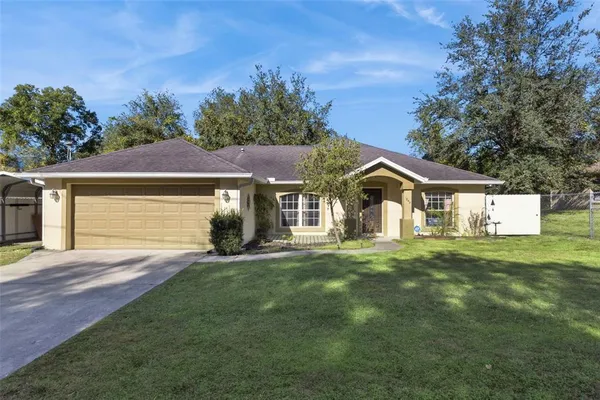 a front view of a house with a yard and trees