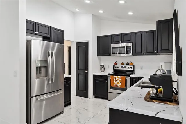 a kitchen with stainless steel appliances granite countertop a refrigerator and a stove