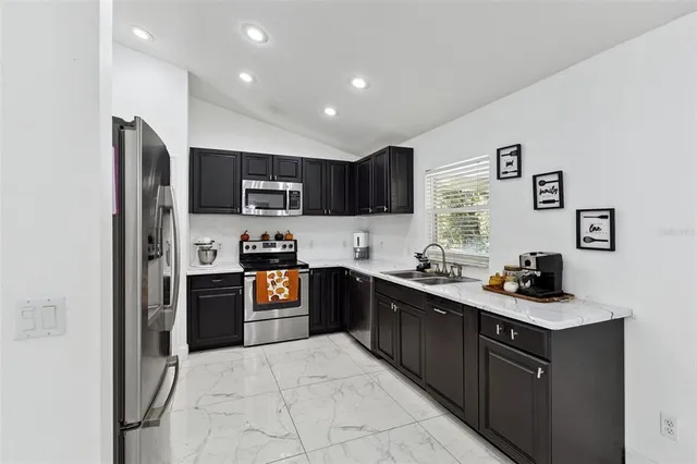 a kitchen with a sink a stove top oven and refrigerator