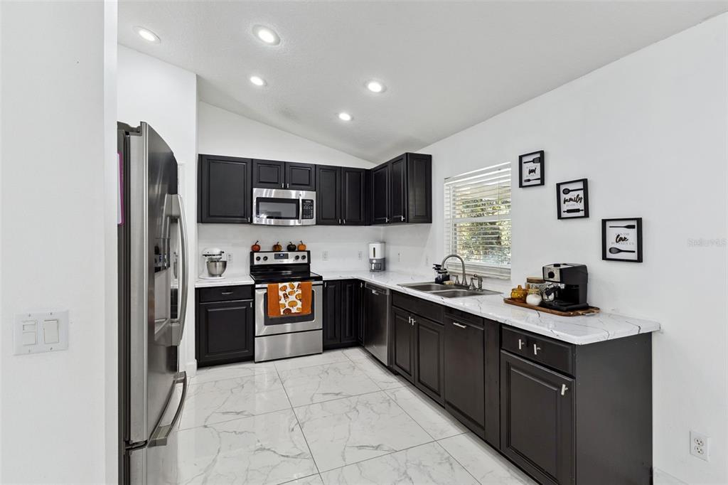 1865 15th Street Orange City, FL 32763 - Photo 3 of 21 a kitchen with a sink a stove top oven and refrigerator