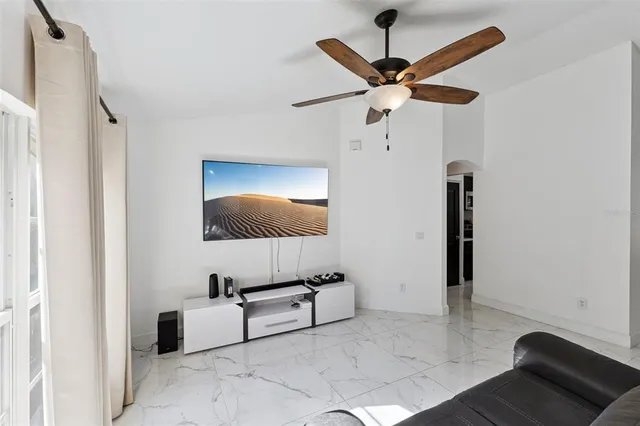 a living room with furniture and a ceiling fan