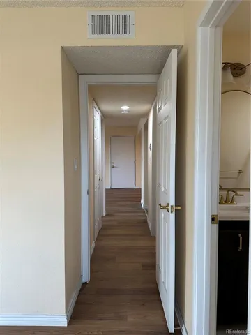 a view of a hallway with wooden floor and closet