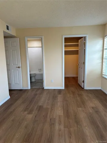 a view of empty room with wooden floor and closet