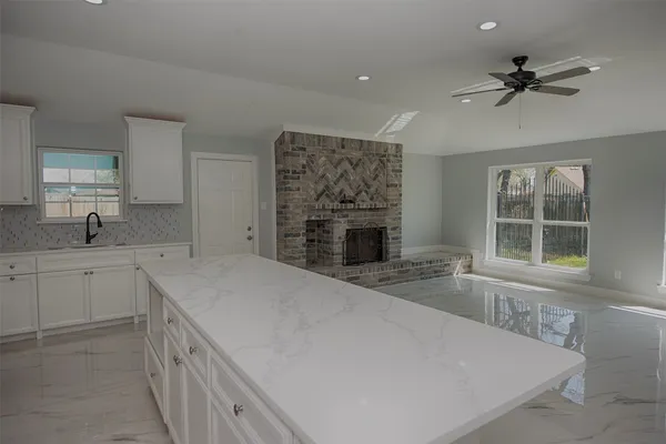 a spacious bathroom with a granite countertop sink a mirror and a bathtub
