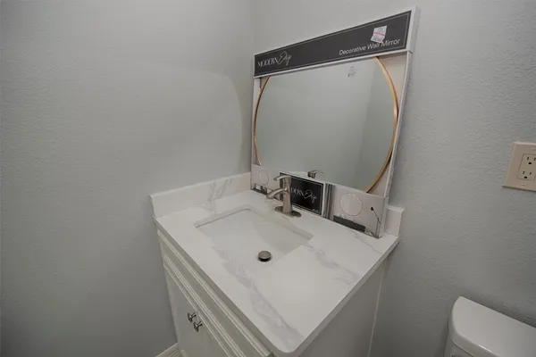a bathroom with a sink toilet and mirror