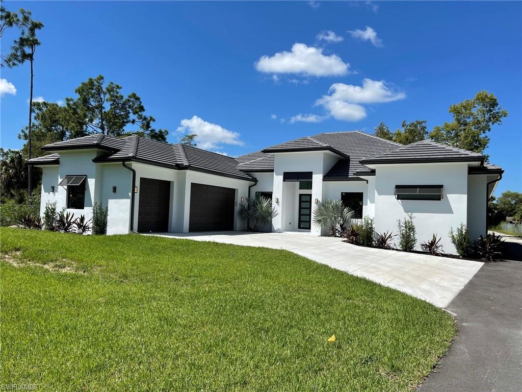 3203 68th Street Southwest Naples, FL 34105 - Photo 1 of 34 a front view of a house with a yard