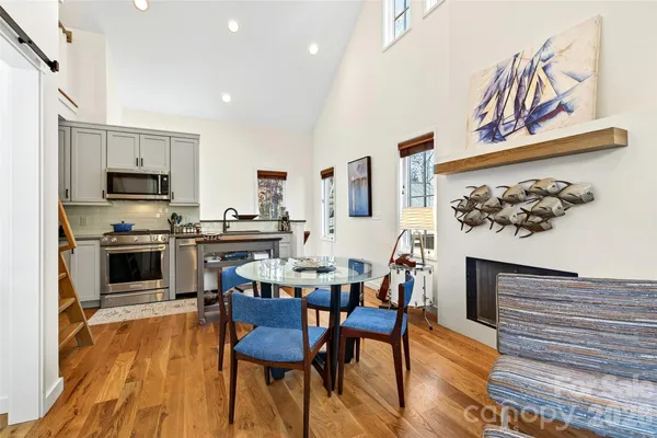 a kitchen with stainless steel appliances kitchen island granite countertop a stove a sink a microwave and a dining table