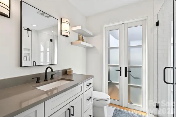 a bathroom with a granite countertop sink a toilet and a mirror