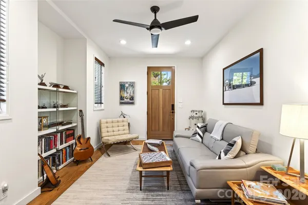 a living room with furniture a rug and a book shelf