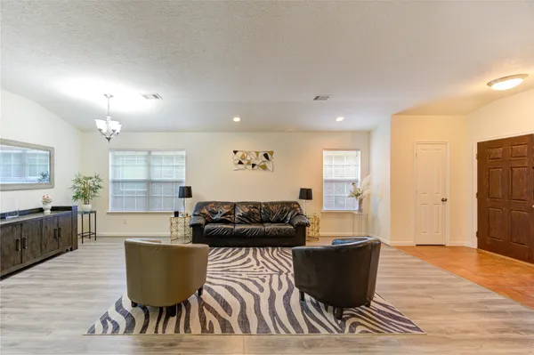 a living room with furniture and a wooden floor