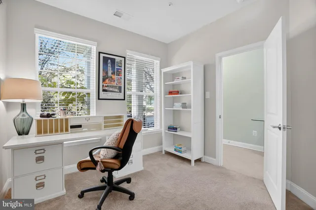 a view of a workspace with furniture and a window