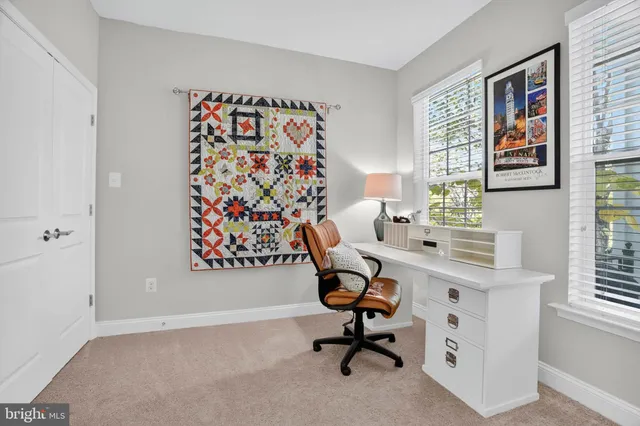 a view of a workspace with furniture and a window