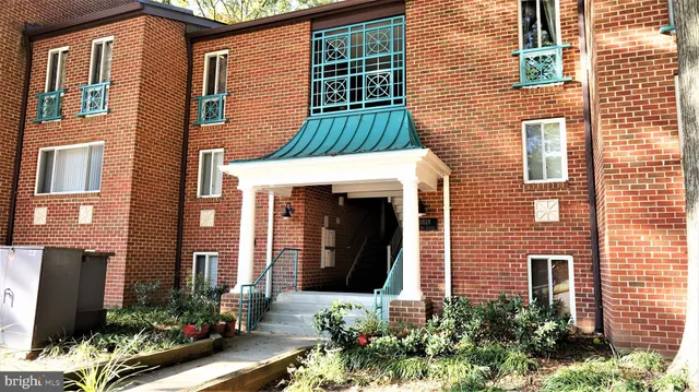 a view of a brick house with a windows and flower plants