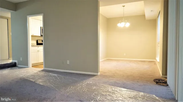 a view of a room with kitchen and wooden floor