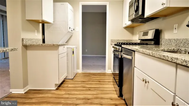 a kitchen with stainless steel appliances granite countertop a refrigerator and a stove