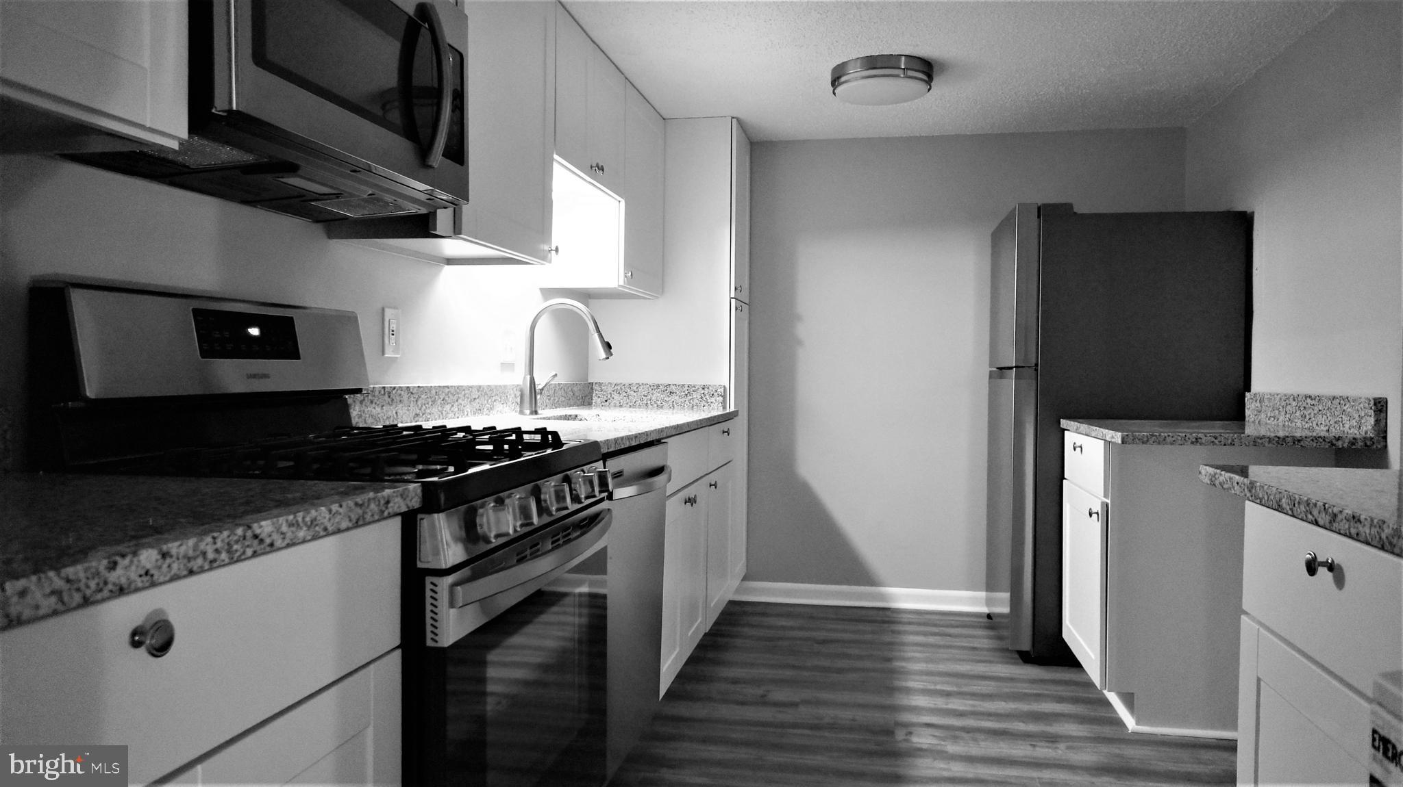 11818 Breton Court, Unit 1A Reston, VA 20191 - Photo 9 of 38 a kitchen with stainless steel appliances granite countertop a stove and a sink