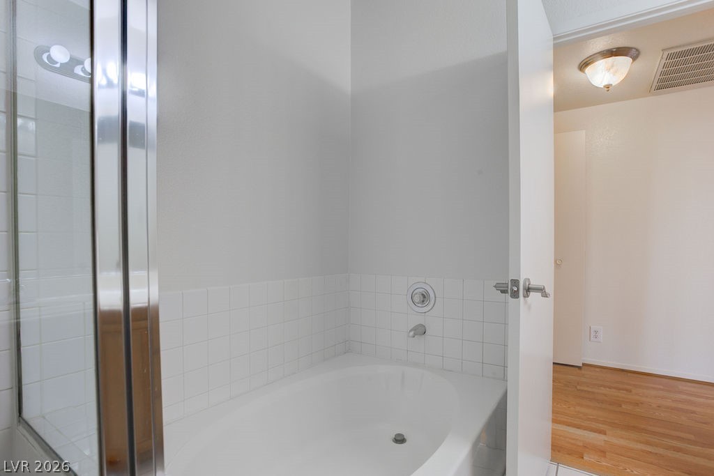 2201 Ramsgate Drive, Unit 326 Henderson, NV 89074 - Photo 35 of 44 Bathroom with a garden tub and wood finished floors