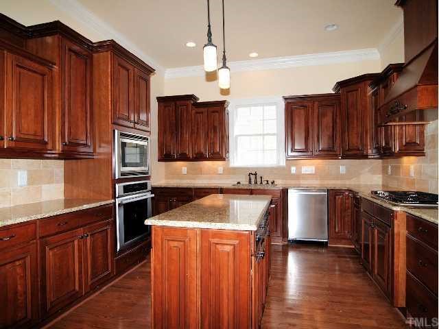 3109 Raymond Street Raleigh, NC 27607 - Photo 5 of 12 Gourmet kitchen boasts custom cabinetry, granite countertops, center island, and stainless appliances.