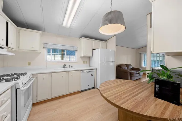 a room with kitchen island granite countertop stainless steel appliances a sink stove and refrigerator