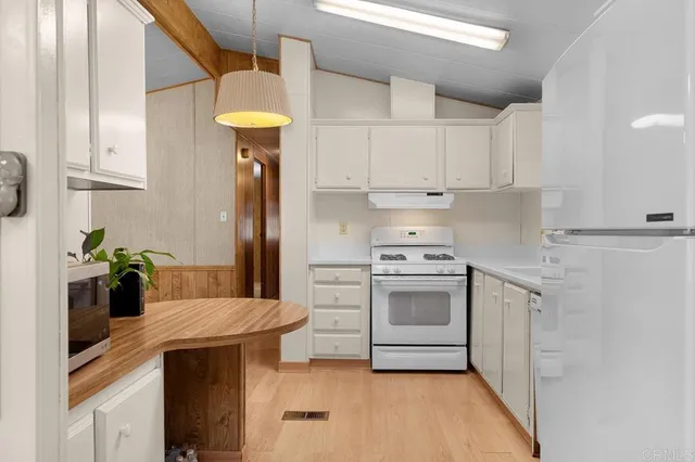 a kitchen with stainless steel appliances granite countertop a sink a stove and refrigerator