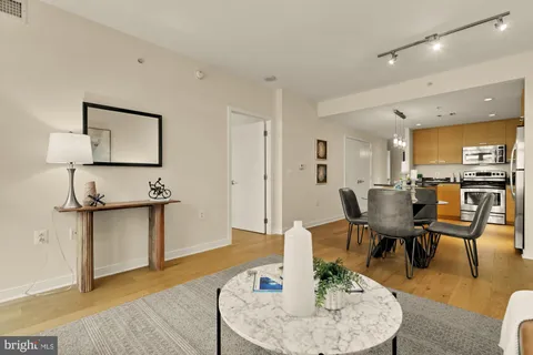 a living room with furniture a rug and kitchen view