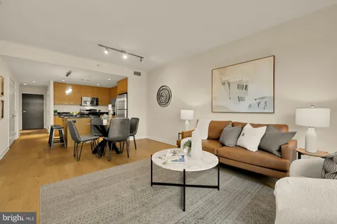 a living room with furniture kitchen view and a table