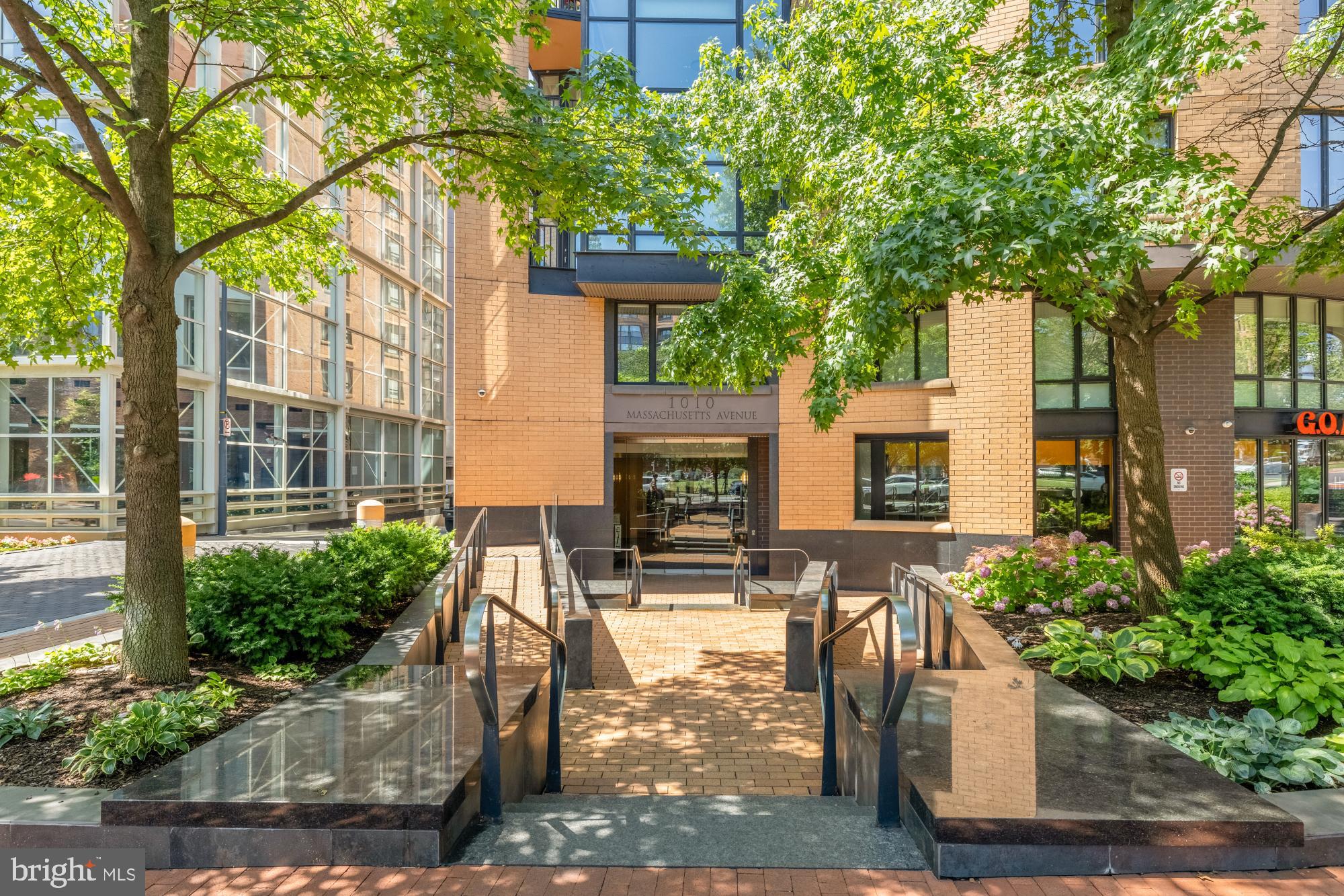 1010 Massachusetts Avenue Northwest, Unit 207 Washington, DC 20001 - Photo 25 of 31 a view of a patio with table and chairs potted plants and large tree