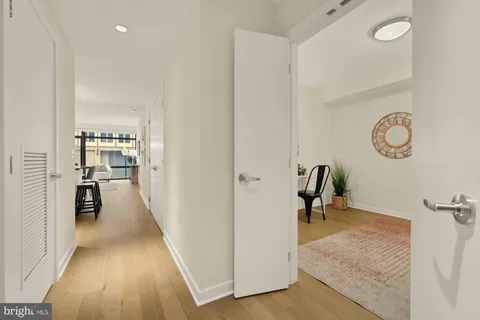 a view of a hallway with wooden floor and a living room