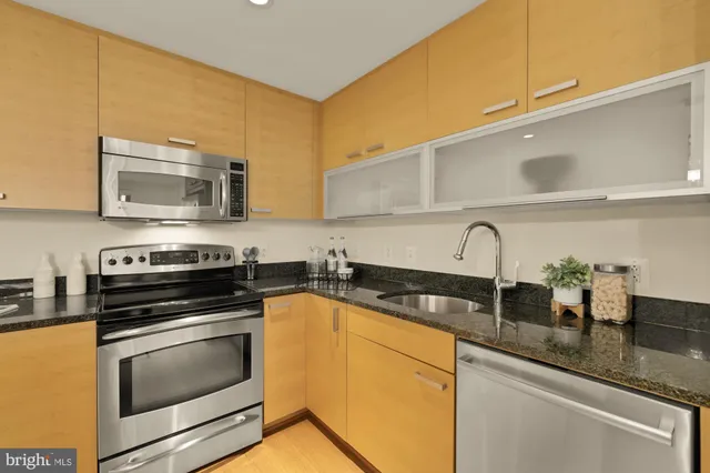 a kitchen with granite countertop a sink a stove and cabinets