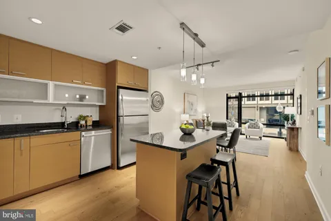 a kitchen with stainless steel appliances a table chairs and a refrigerator