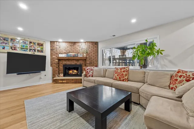 a living room with furniture a flat screen tv and a fireplace