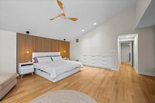 a spacious bedroom with a bed and a chandelier