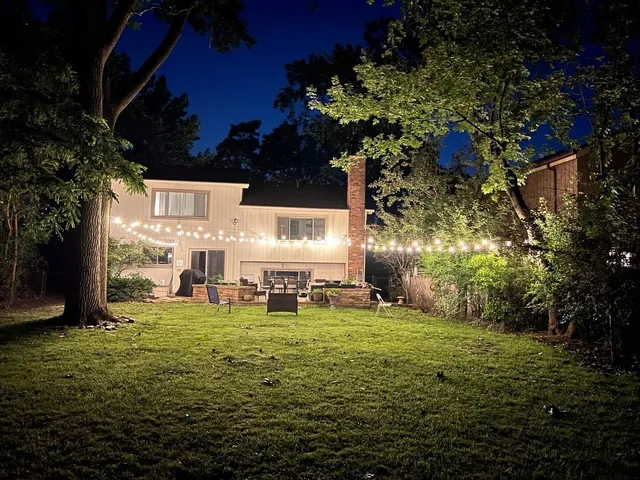 a view of a big yard with table and chairs and potted plants